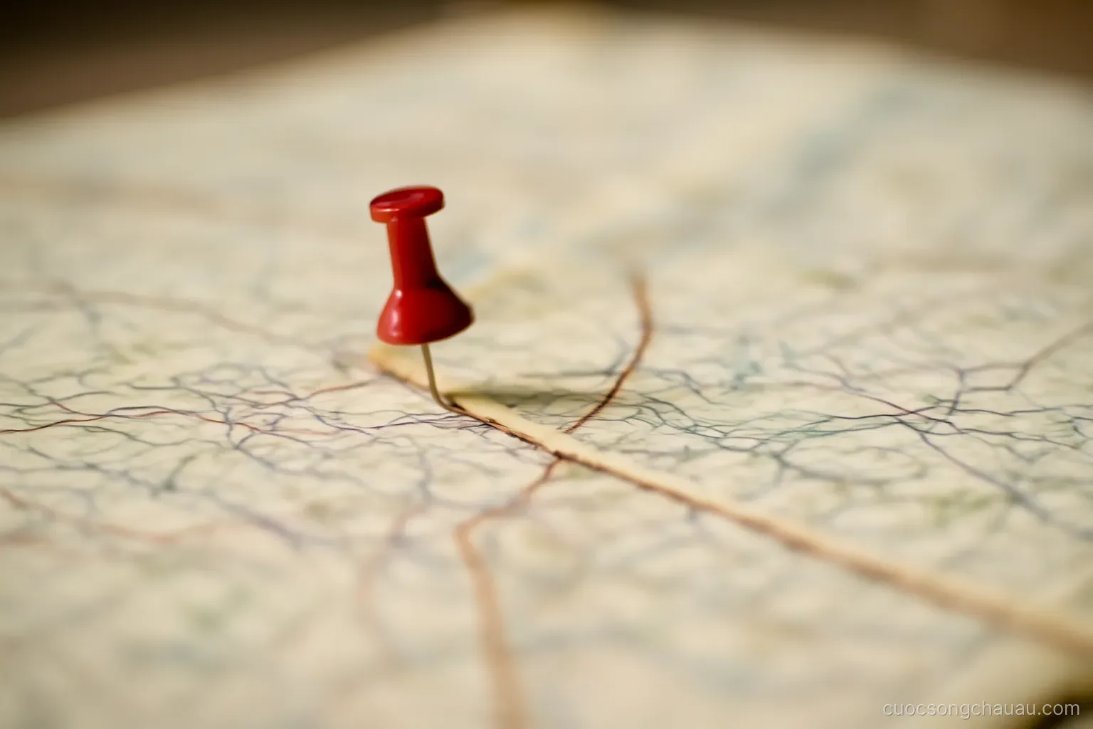 a map with a single pin stuck into one point and a piece of string leading away from it